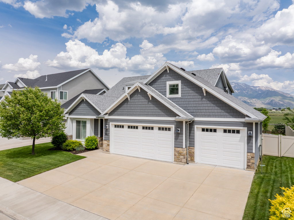 Craftsman house with stone siding, concrete driveway, a garage, and roof with shingles