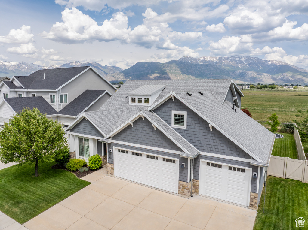 Craftsman house featuring stone siding, concrete driveway, and a mountain view