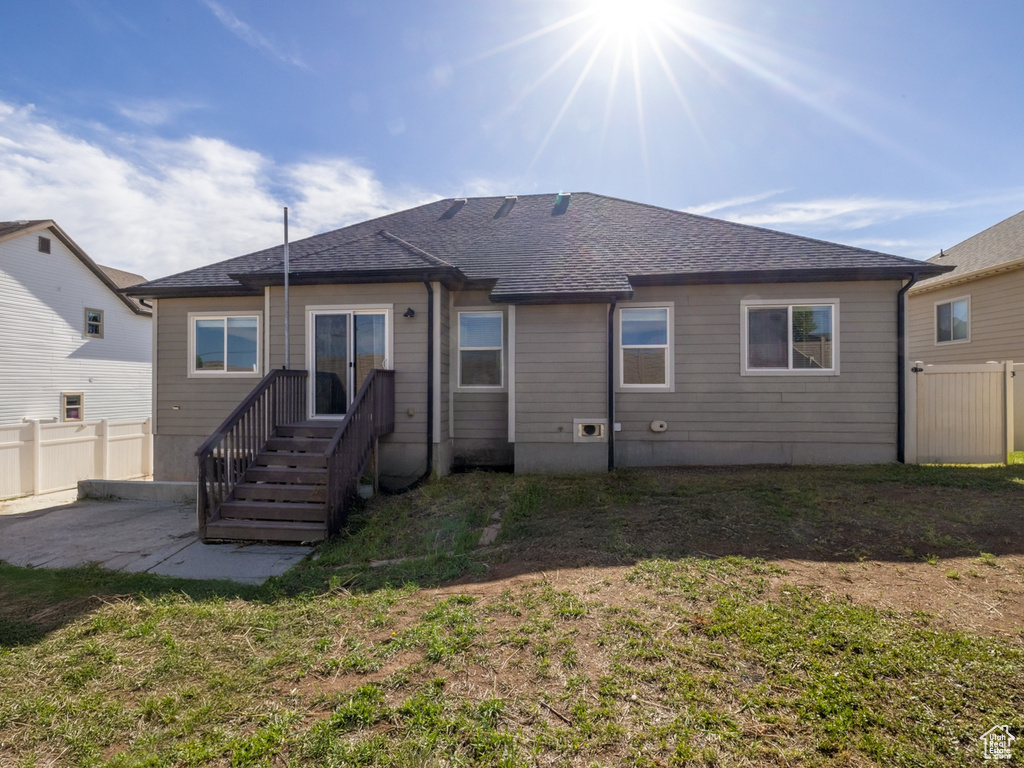 Rear view of property with a patio area and a shingled roof