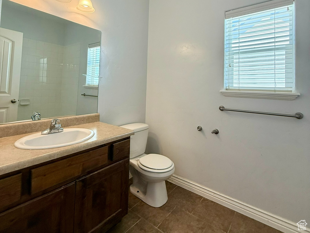 Bathroom featuring toilet, vanity, tile patterned floors, and baseboards