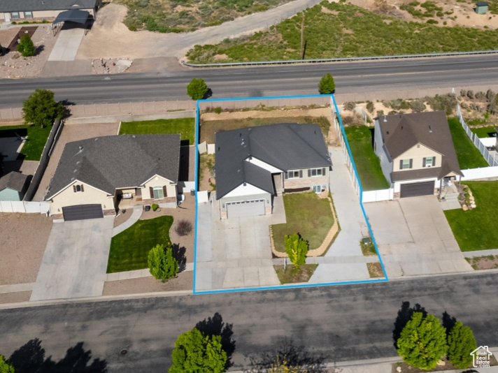 Aerial view of residential area featuring property boundaries highlighted and a mountain backdrop