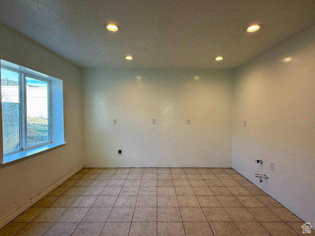 Empty room featuring light tile patterned floors and recessed lighting