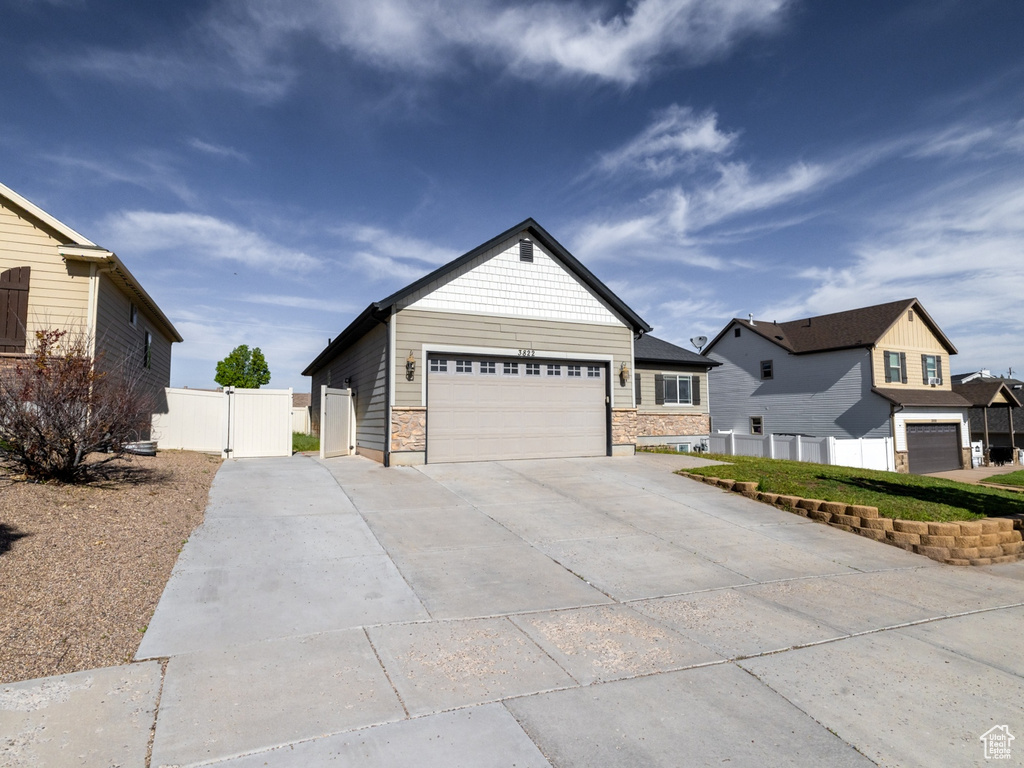 Ranch-style home with driveway, fence, a garage, and a residential view