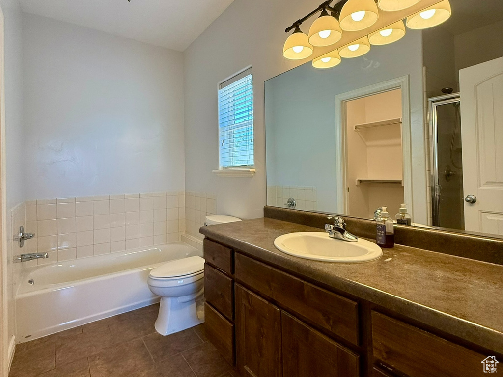 Full bath with tile patterned floors, a bath, a shower stall, vanity, and toilet