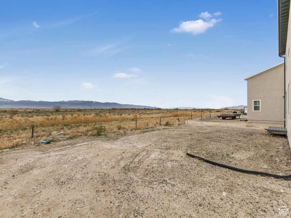 View of yard with a rural view and a mountain view
