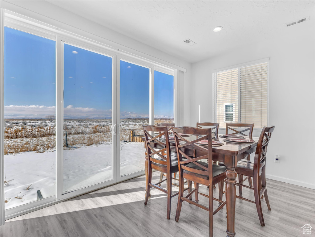 Dining room featuring wood finished floors, visible vents, and baseboards