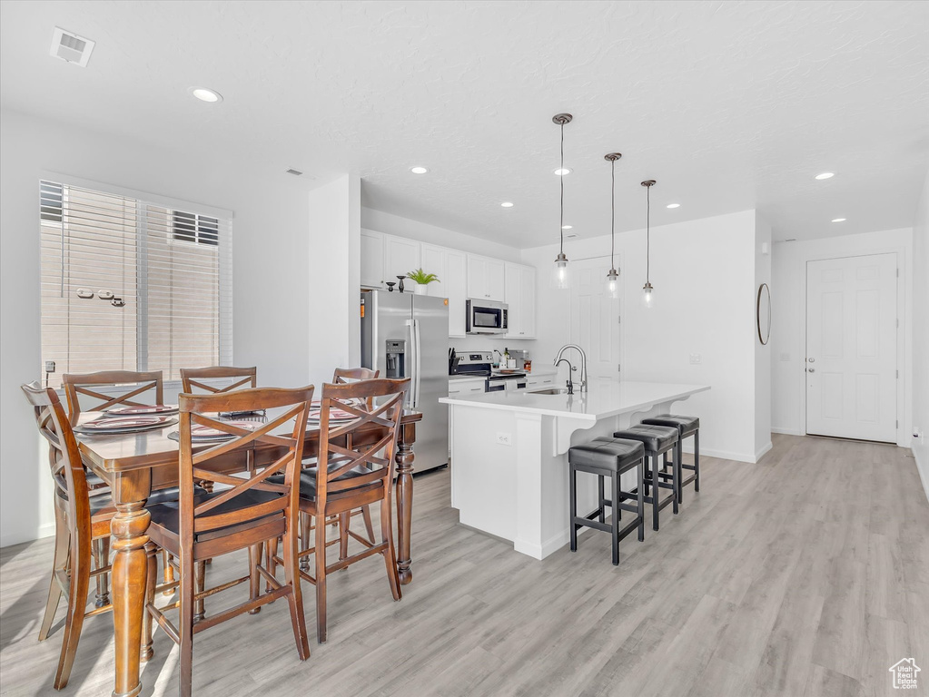 Dining room with recessed lighting, visible vents, and light wood finished floors