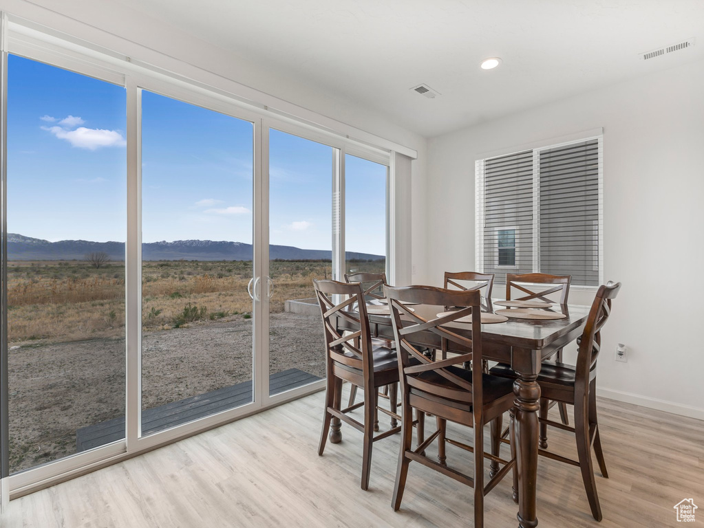 Dining area with a mountain view, visible vents, recessed lighting, light wood finished floors, and baseboards