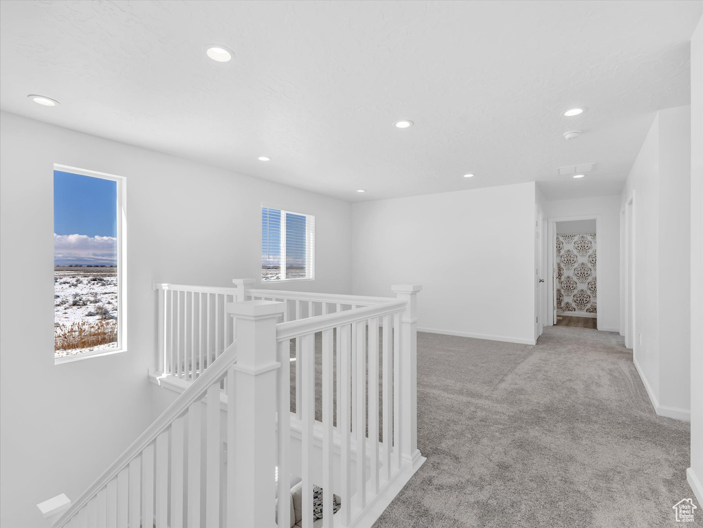 Hall featuring baseboards, recessed lighting, an upstairs landing, and light colored carpet