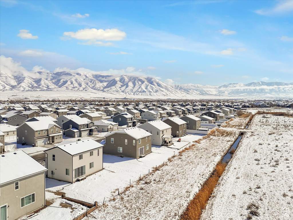 Snowy aerial view featuring a residential view and a mountain view