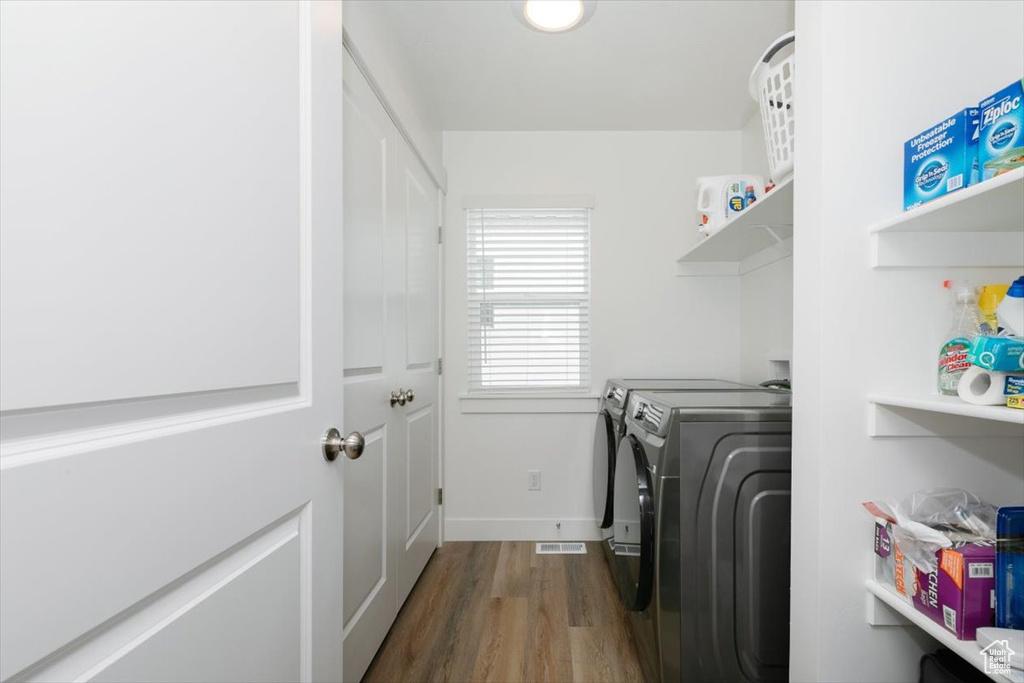 Laundry room with washing machine and dryer and dark hardwood / wood-style floors