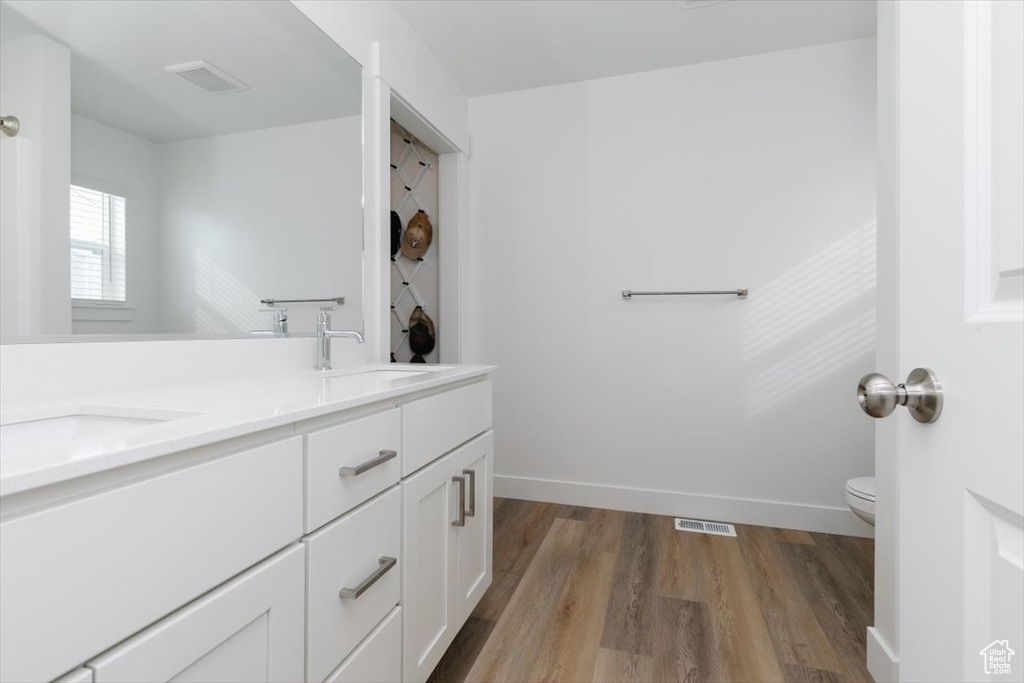 Bathroom with vanity, toilet, and hardwood / wood-style floors