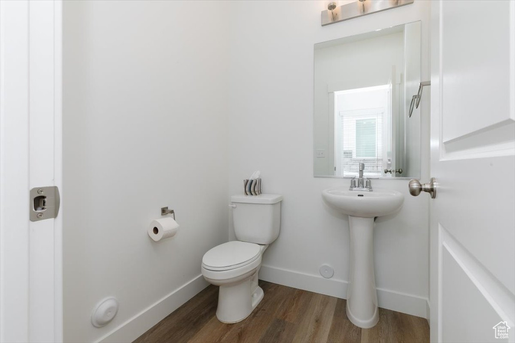 Bathroom with toilet, sink, and wood-type flooring