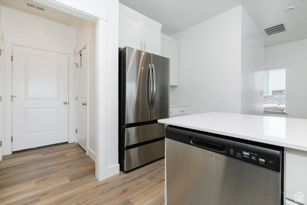 Kitchen featuring white cabinetry, light wood-type flooring, and stainless steel appliances