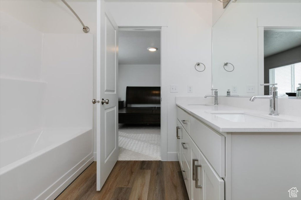 Bathroom featuring shower / bath combination, vanity, and hardwood / wood-style floors