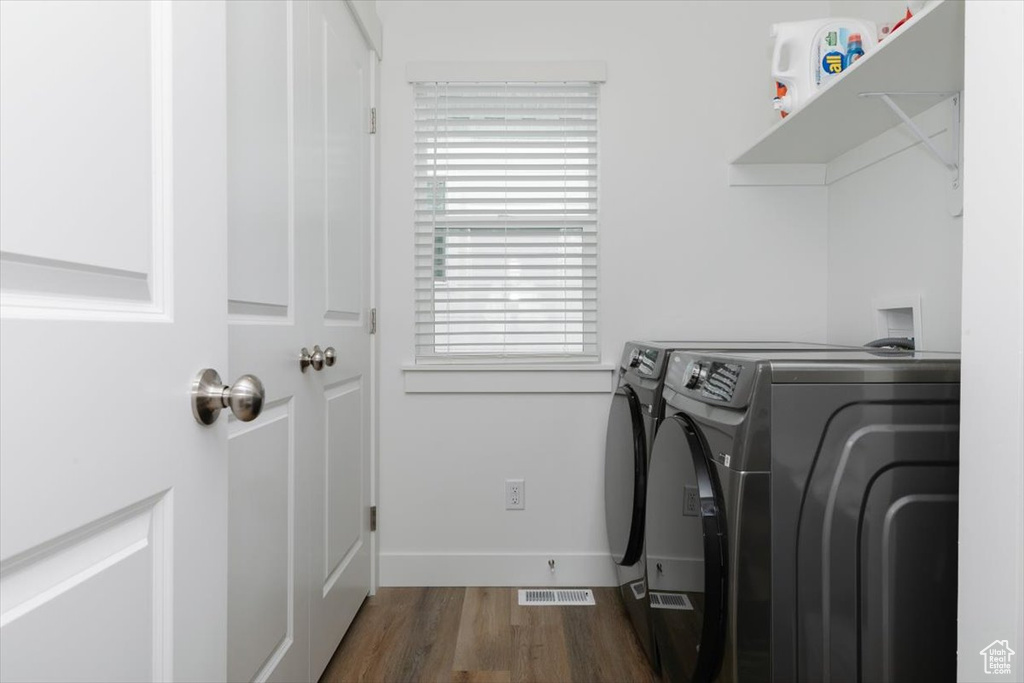 Laundry area featuring washing machine and clothes dryer and dark hardwood / wood-style floors