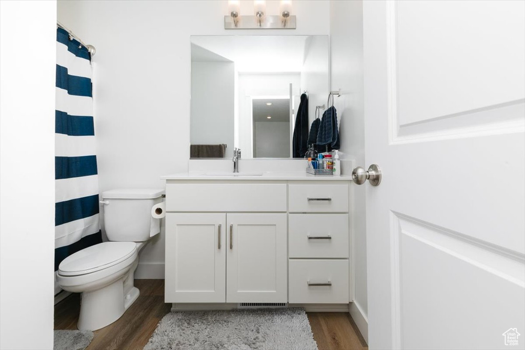 Bathroom with toilet, wood-type flooring, and vanity