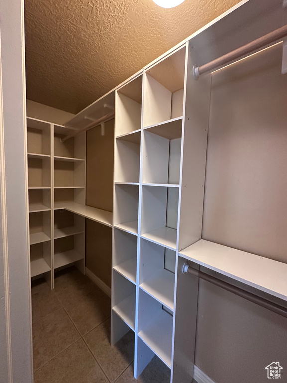 Spacious closet featuring dark tile patterned flooring