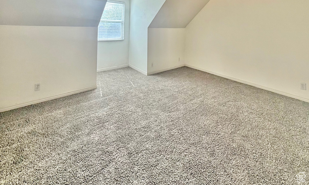Bonus room featuring lofted ceiling and light carpet