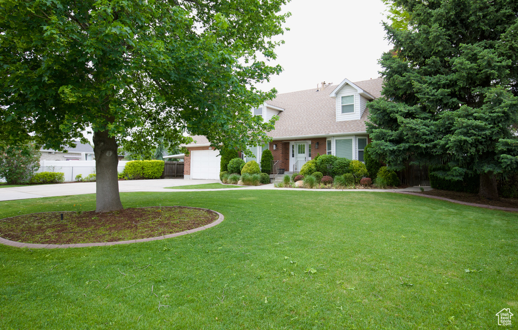 View of front of house with driveway, an attached garage, roof with shingles, and brick siding