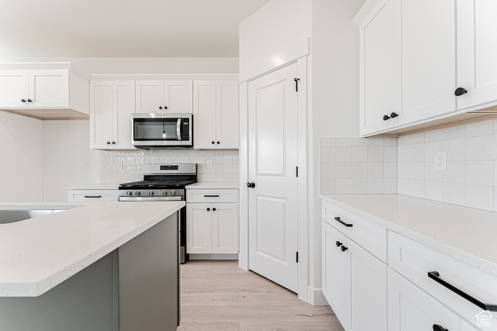 Kitchen featuring stainless steel appliances and white cabinetry