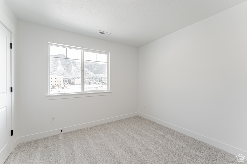 Spare room featuring carpet floors and baseboards