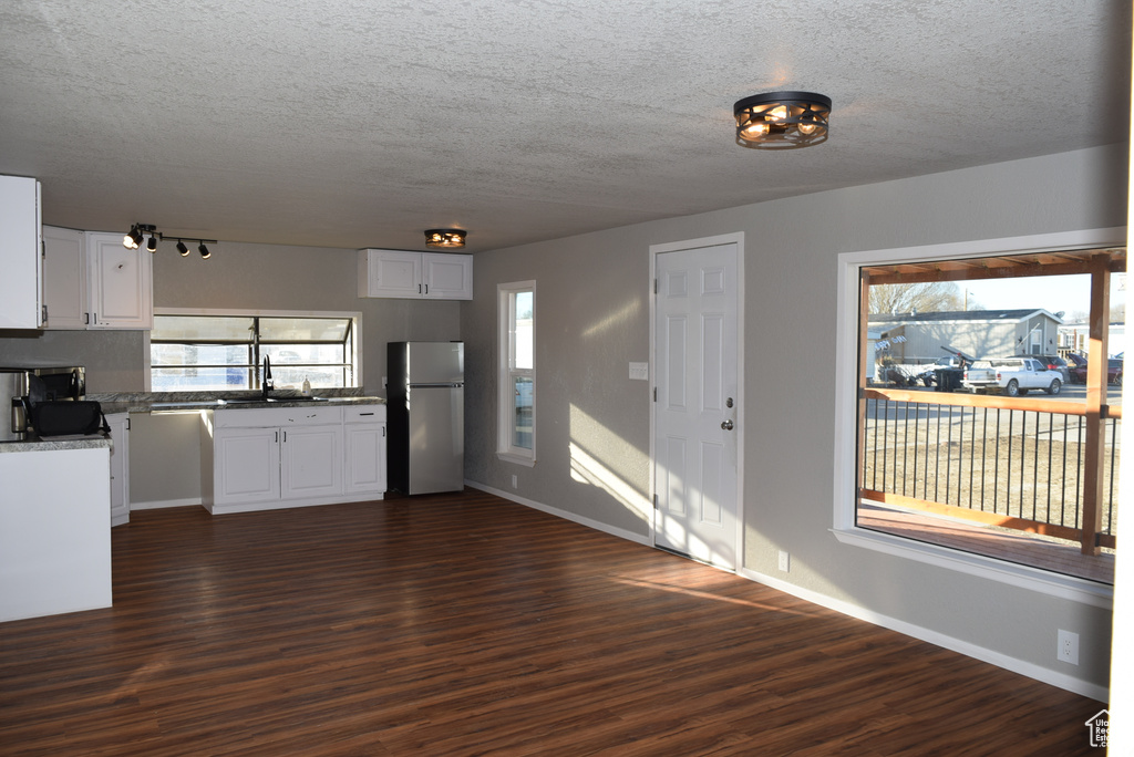 Kitchen with white cabinets, dark wood-style floors, and stainless steel appliances