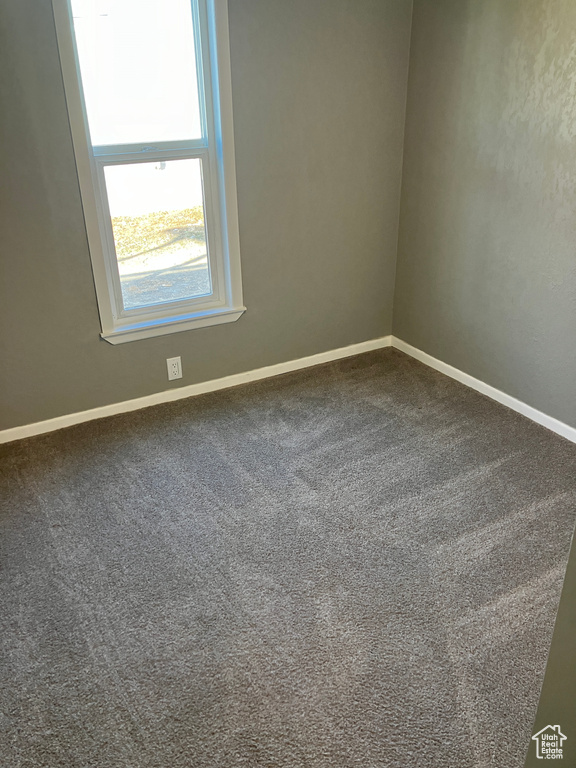 Carpeted empty room with baseboards