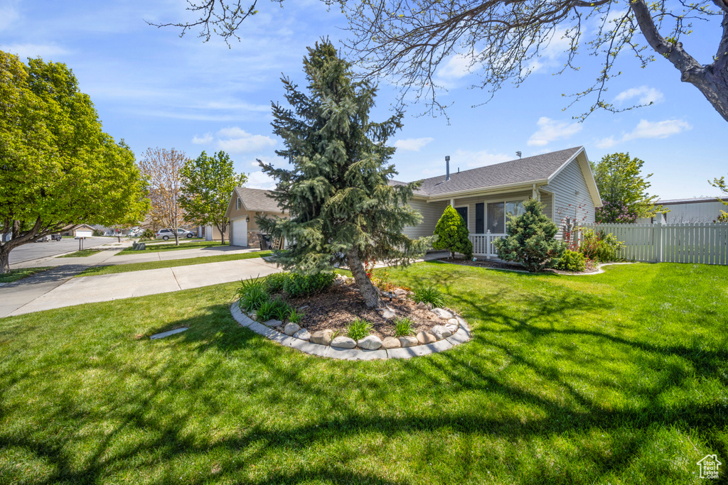 Exterior space with an attached garage, fence, and concrete driveway