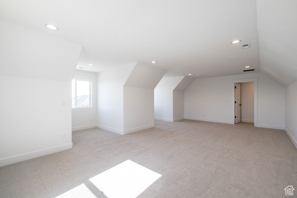 Bonus room with lofted ceiling, light colored carpet, and recessed lighting