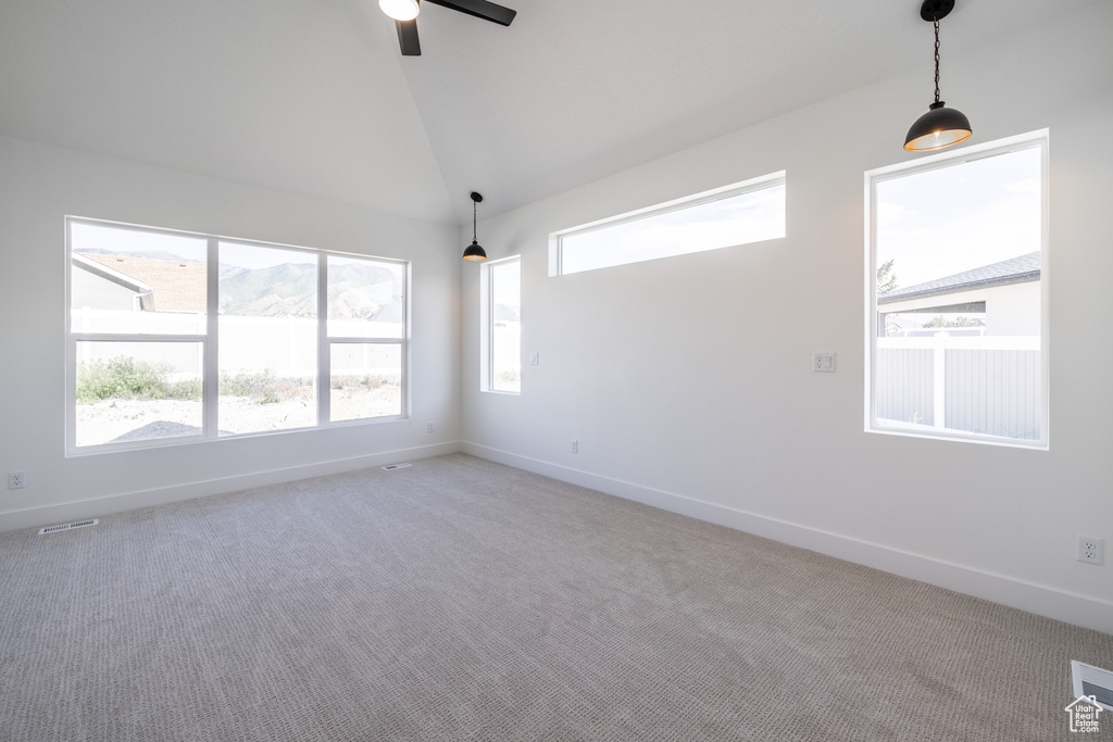 Empty room featuring carpet floors, a ceiling fan, and high vaulted ceiling