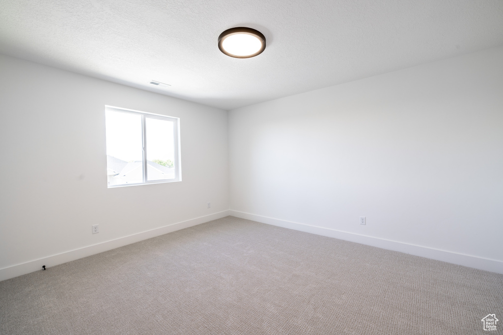 Unfurnished room featuring light colored carpet and baseboards