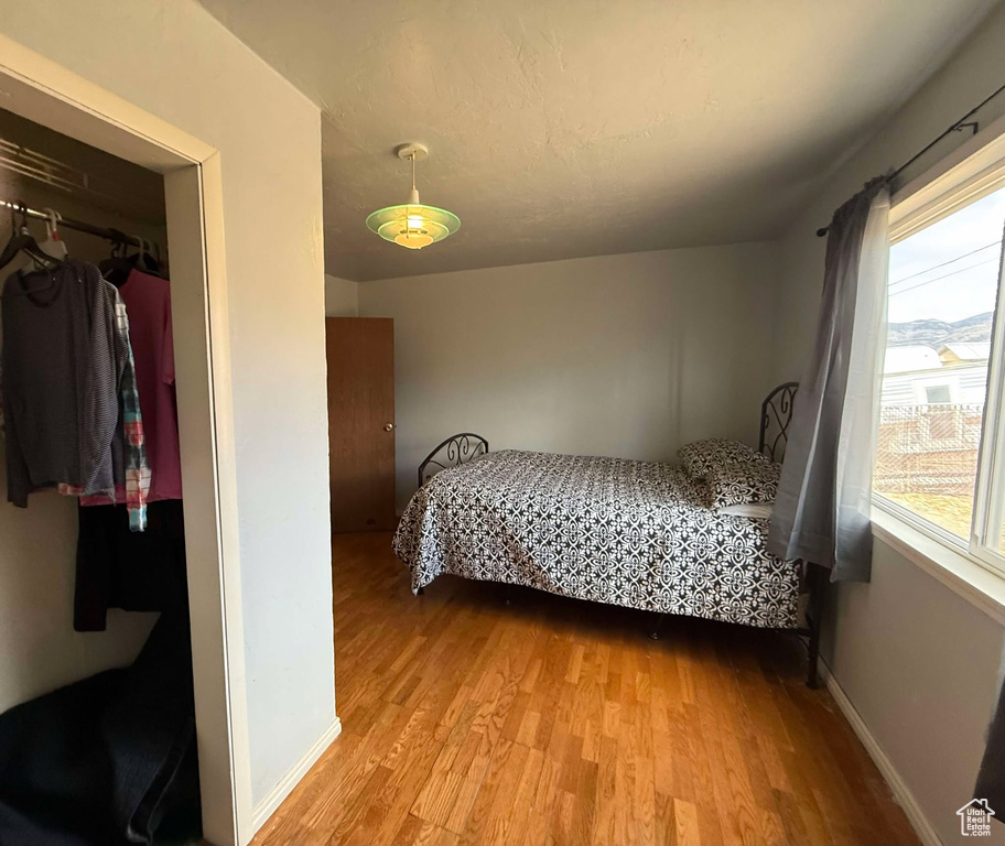 Bedroom with a closet, baseboards, and light wood finished floors