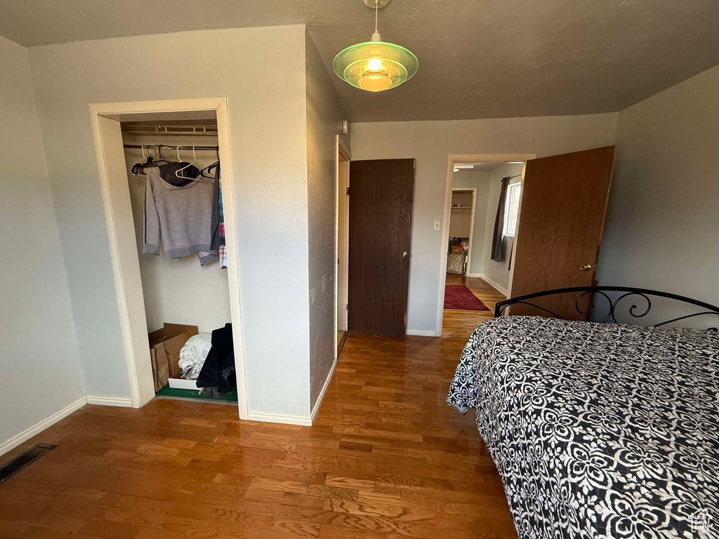 Bedroom featuring visible vents, baseboards, and wood finished floors