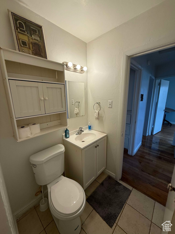 Bathroom with baseboards, toilet, vanity, and tile patterned floors