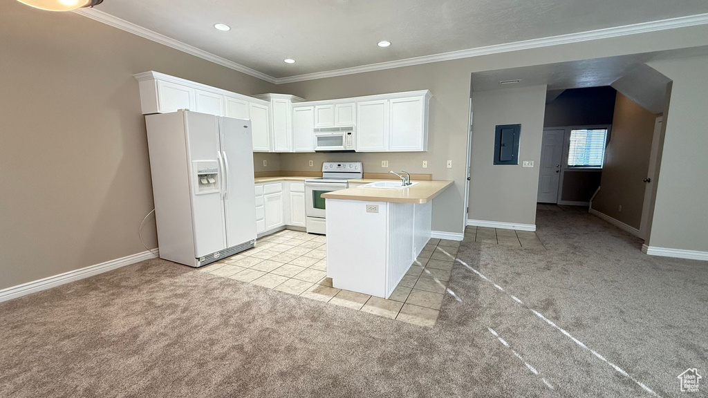 Kitchen featuring light countertops, light colored carpet, white cabinets, white appliances, and a peninsula