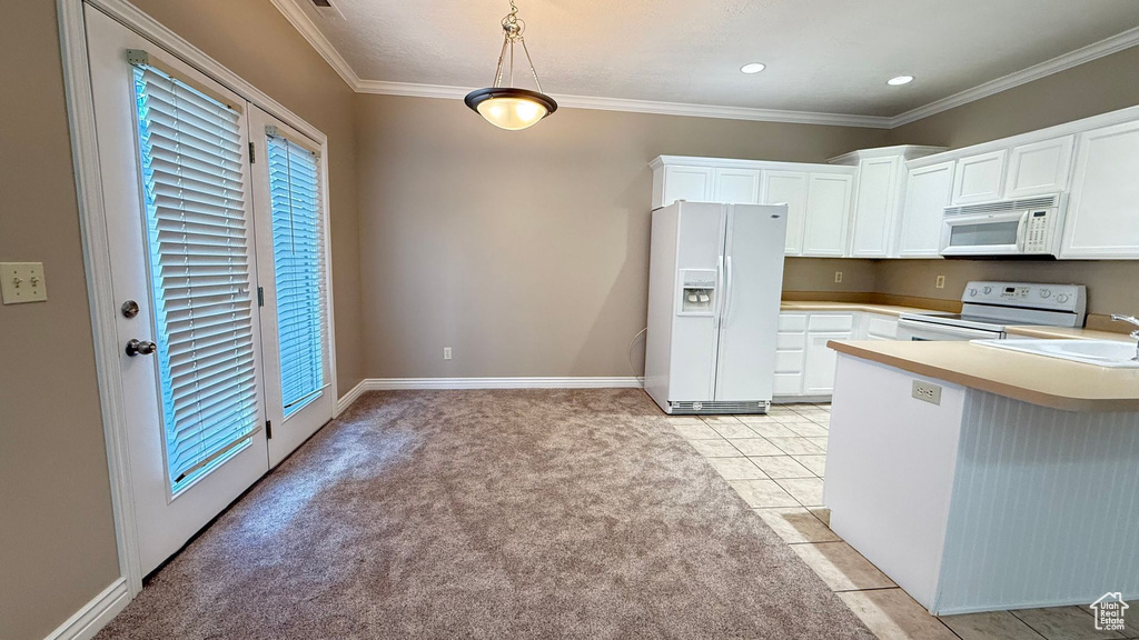 Kitchen featuring decorative light fixtures, light countertops, white cabinetry, white appliances, and a peninsula