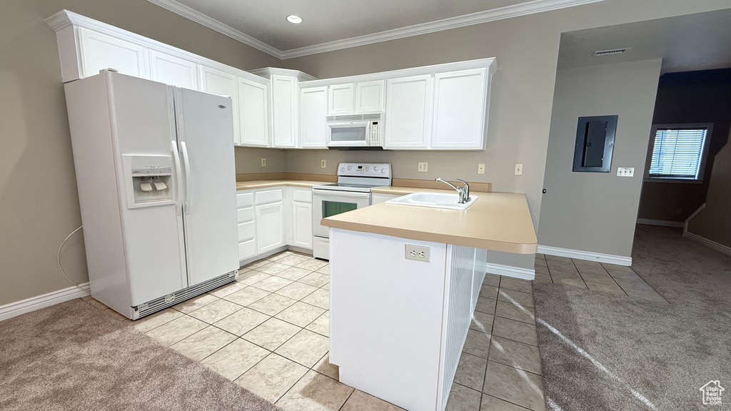 Kitchen with light countertops, a sink, white appliances, electric panel, and a peninsula