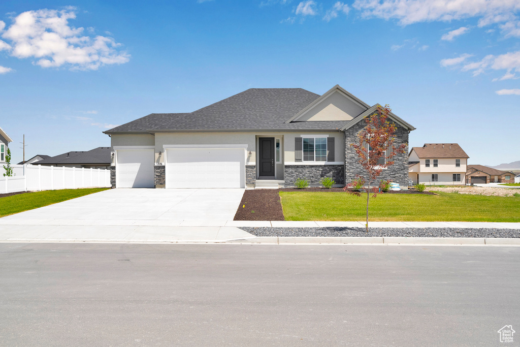 View of front of house featuring stone siding, an attached garage, concrete driveway, and stucco siding