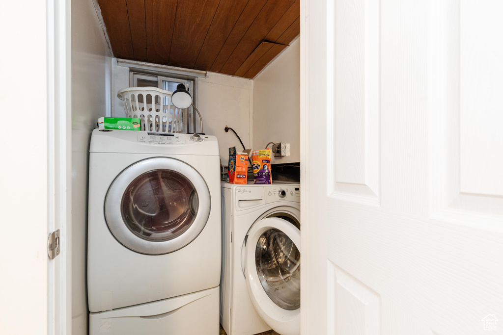 Laundry room with laundry area, wooden ceiling, and washing machine and dryer