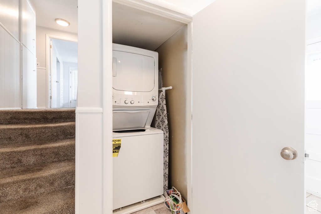 Washroom featuring stacked washer and dryer and laundry area