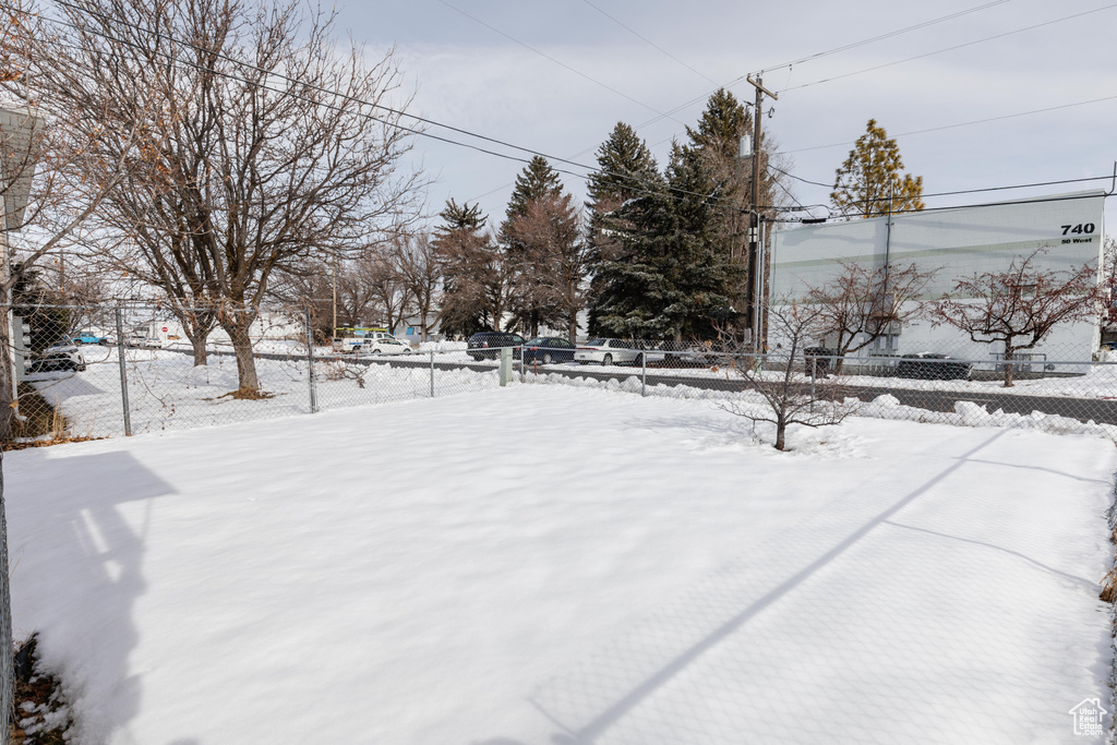 Yard layered in snow with fence