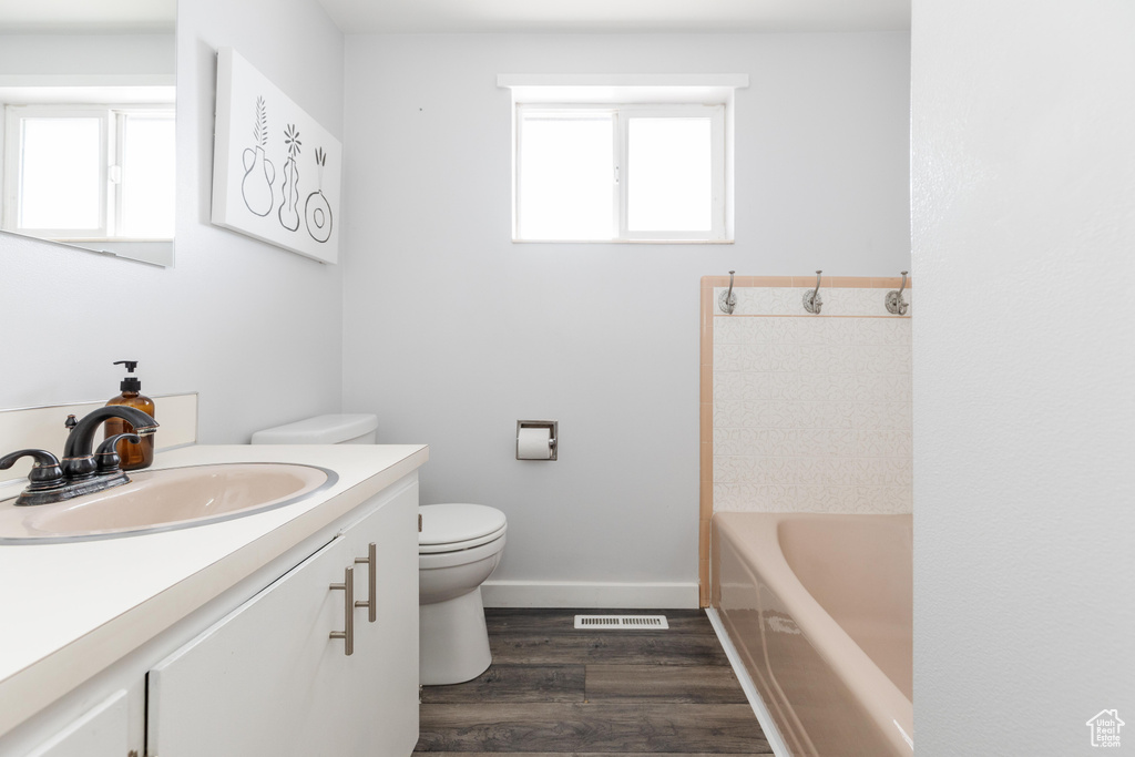 Full bathroom with a tub, wood finished floors, a wealth of natural light, and vanity