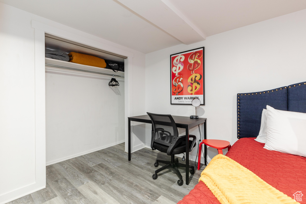 Bedroom with wood finished floors and baseboards