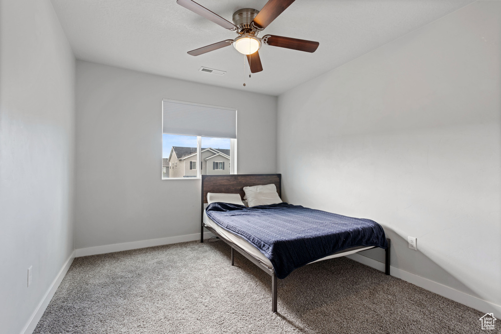 Carpeted bedroom featuring visible vents, ceiling fan, and baseboards