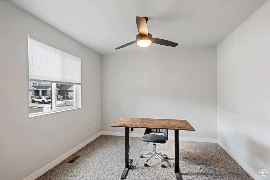 Office with ceiling fan, carpet floors, visible vents, and baseboards