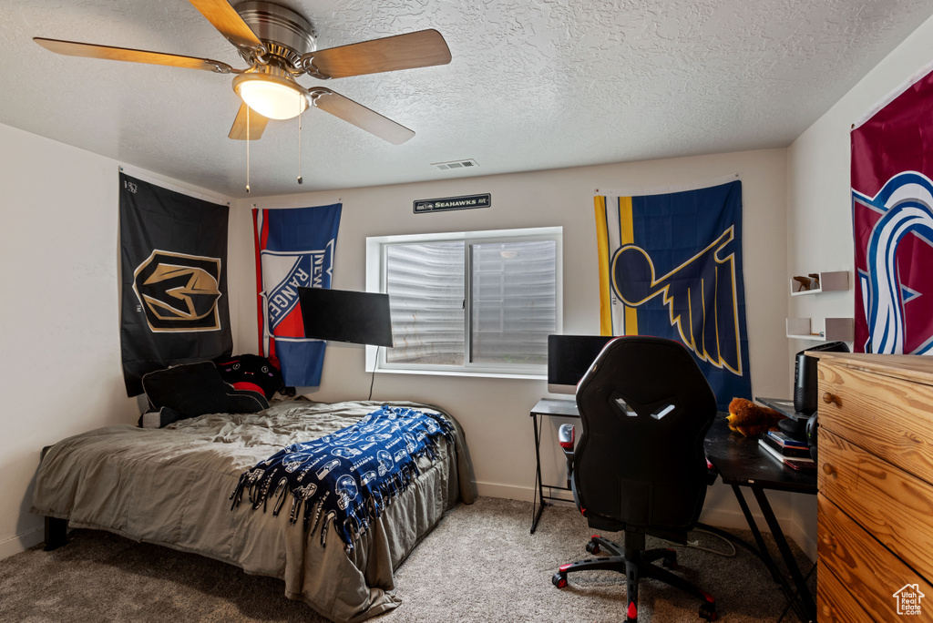 Bedroom featuring a textured ceiling, carpet floors, visible vents, a ceiling fan, and baseboards
