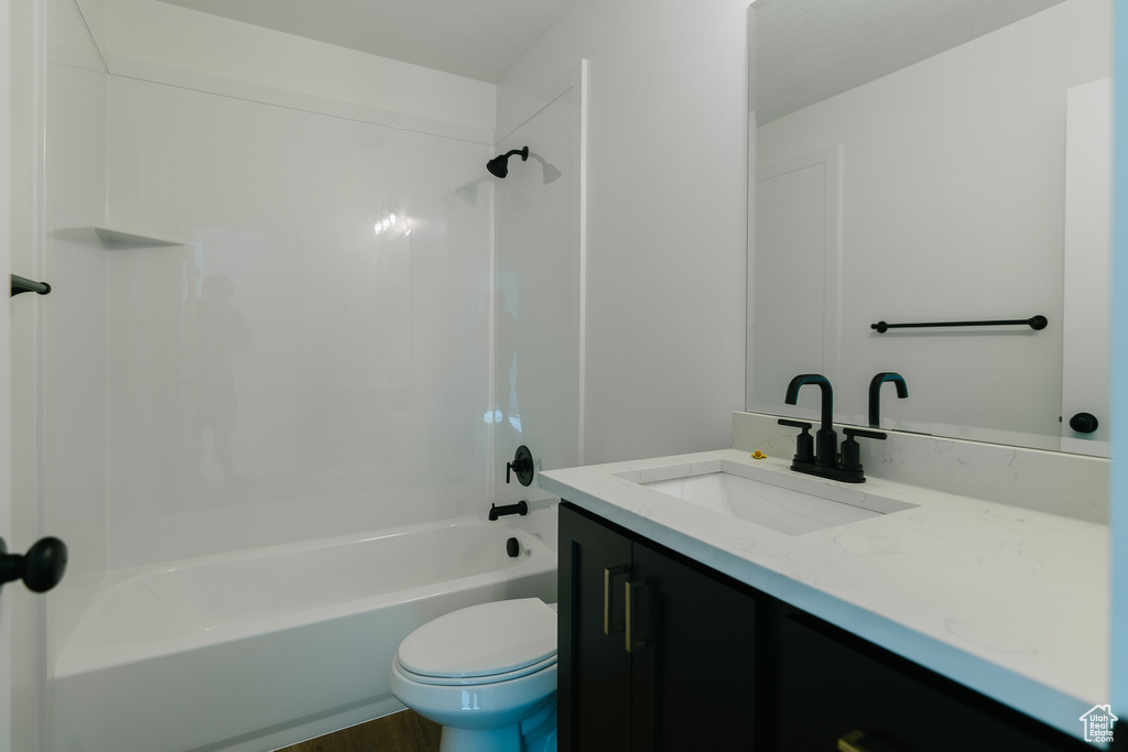 Bathroom featuring toilet, tub / shower combination, and vanity