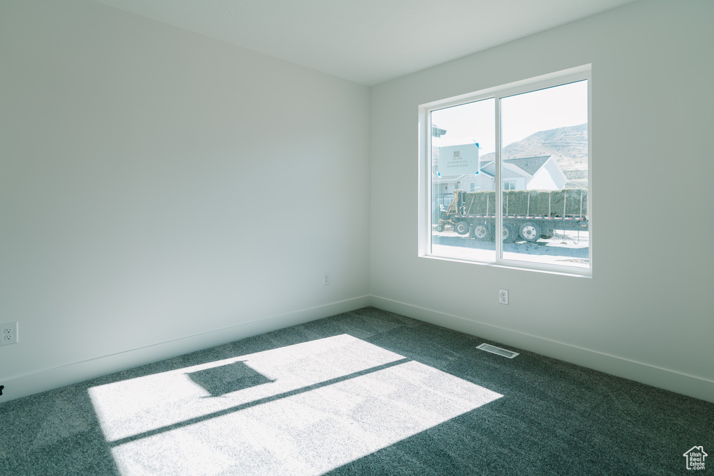 Spare room with baseboards, carpet, and visible vents