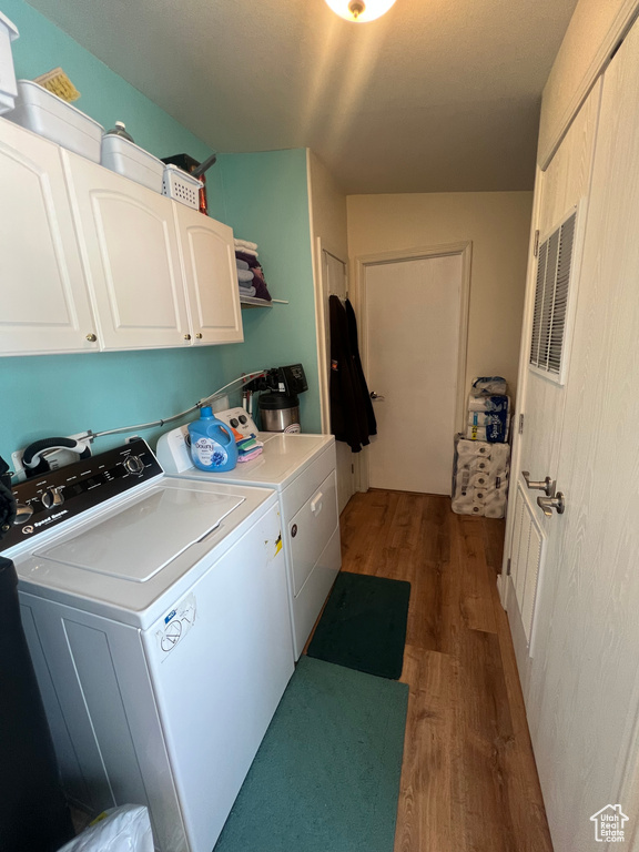 Laundry room with cabinet space, dark wood-style floors, and independent washer and dryer